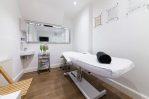 Beauty Therapy salon room with a bed and mirror
